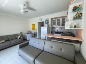 sala de estar con sofá y cocina en Res Palmeiras, en Bombinhas