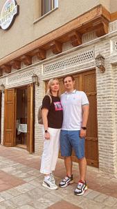 a man and a woman standing in front of a building at Oasis Boutique in Bukhara