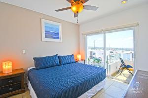 a bedroom with a bed with a blue comforter and a window at Oceanview Living Space & Balcony with FiberOptic WiFi! in La Paz +80 photos