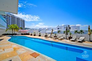 a swimming pool with chairs and a building at Oceanview Living Space & Balcony with FiberOptic WiFi! in La Paz