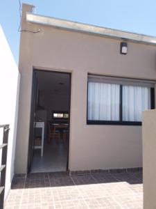 a white house with a door and a table at Confort urbano - Departamento in Venado Tuerto