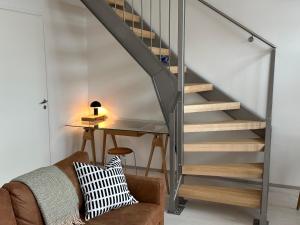 escalera en una sala de estar con sofá y mesa en Cozy Design Loft next to Metro en Helsinki