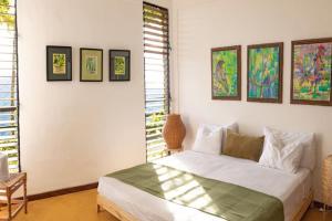 a bedroom with a bed and some paintings on the wall at Rincones del Mogote 