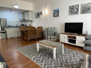 a living room with a couch and a tv at The Herolds Bay 611 in Herolds Bay