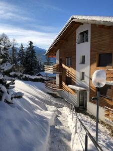 a building with snow on the ground next to it at Crans-Montana Duplex Lodge in Crans-Montana