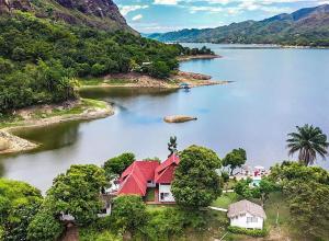 uma ilha com uma casa vermelha no meio de um lago em Isla Tortuga - Prado - Deportes Náuticos - Cerca a Bogotá - Cerca a Ibagué em Prado