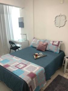 a bedroom with a bed with a tray of food on it at Kit completa - Parque Norte in Brasília