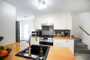 a kitchen with white cabinets and a sink at Confo28 Chute Montmorency Parking in Quebec City