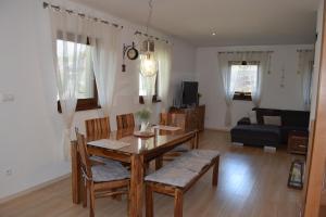 ein Wohnzimmer mit einem Tisch, Stühlen und einem Sofa in der Unterkunft Luxury Chalet Stará Lesná in Stará Lesná