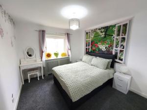 a small bedroom with a bed and a window at The Blossom - Largs in Largs