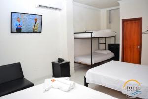Cette chambre comprend 2 lits superposés et une télévision. dans l'établissement Hotel Roca & Mar, à Santa Marta