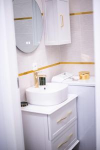 La salle de bains blanche est pourvue d'un lavabo et d'un miroir. dans l'établissement Isabel Apartaments Old Town, à Padoue