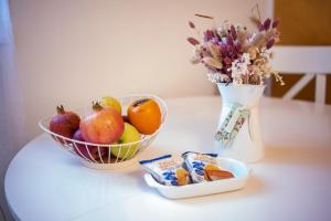 a table with a bowl of fruit and a vase of flowers at Isabel Apartaments Old Town in Padova +20 photos