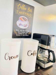 tres tazas de café sentadas en un mostrador junto a una cafetera en Affordable Staycation with Netflix, Retro Game Videoke, en Cainta