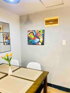 una mesa de comedor con sillas y una pintura en la pared en Affordable Staycation with Netflix, Retro Game Videoke, en Cainta