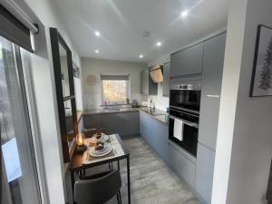 a kitchen with a table and a stove top oven at Mackie lodge in Luss