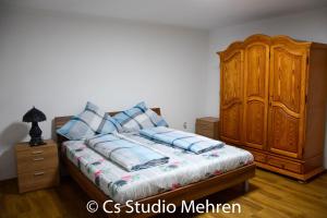 a bedroom with a bed and a wooden cabinet at Apartament 2 camere in Ellscheid