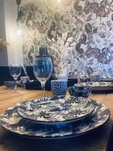 una mesa con un plato y vasos sobre una mesa en GRYT Home - FeWo XXL - Nähe Nordsee, en Ramhusen