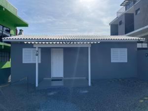 a small blue building with a door in a parking lot at Edícula Cambará in Cambará