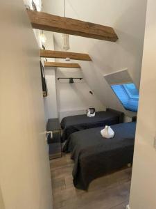 a attic room with two beds and a window at GRYT Home - FeWo XXL - Nähe Nordsee in Ramhusen