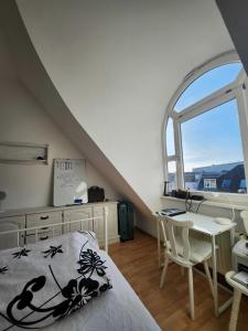 1 dormitorio con cama, escritorio y ventana en One Private room available in a two room apartment in Tegel, Berlin en Berlín