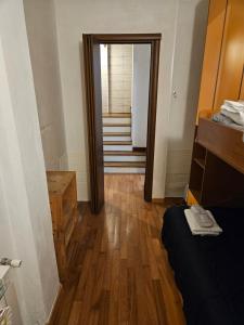 um corredor com uma porta que leva a um quarto com pisos de madeira em Nel Vicolo Nascosto em Legnano