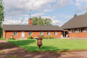 een rood bakstenen huis met een grasveld ervoor bij Bonäs bygdegård in Mora