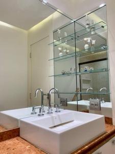 y baño con lavabo blanco y espejo. en Apartamento na quadra da praia en Río de Janeiro