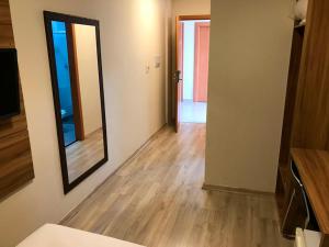 a living room with a mirror and a wooden floor at Minas Platinum Hotel & Convention in Conselheiro Lafaiete