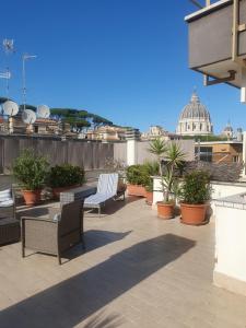 a patio with chairs and plants on a roof at L'Isola di Esme in Rome