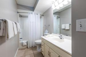 ein Badezimmer mit einem Waschbecken, einem WC und einem Spiegel in der Unterkunft Lake Placid Club Lodges in Lake Placid