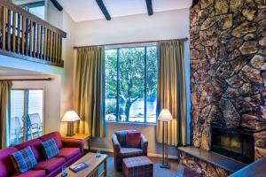 a living room with a red couch and a stone wall at Lake Placid Club Lodges in Lake Placid