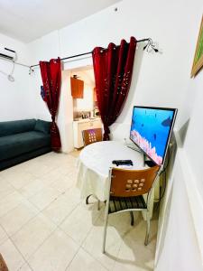 ein Wohnzimmer mit einem Tisch und einem Computer darauf in der Unterkunft КВАРТИРА ВОЗЛЕ МОРЯ! in Haifa