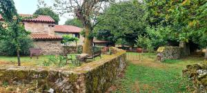 a stone wall in front of a house with a yard at Casas Quo Vadis -Azul in Lugo +10 photos