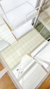 SJO Oasis Hostel في سان خوسيه: غرفة بها رفوف بيضاء وأرضية من البلاط