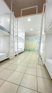 um quarto com beliches brancos e um mural em SJO Oasis Hostel em San José