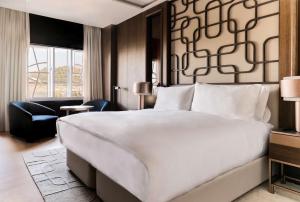 a bedroom with a large white bed and a large window at Nobu Hotel San Sebastián in Donostia-San Sebastián