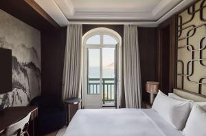 a bedroom with a large bed and a large window at Nobu Hotel San Sebastián in Donostia-San Sebastián