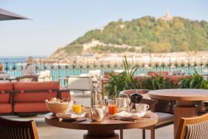 a table with food and drinks on a patio at Nobu Hotel San Sebastián in Donostia-San Sebastián