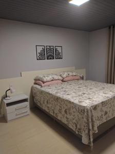 ein Schlafzimmer mit einem Bett mit rosa Kissen darauf in der Unterkunft Apartamento London - Centro Nova Petrópolis in Nova Petrópolis