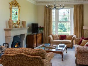 ein Wohnzimmer mit 2 Sofas und einem Kamin in der Unterkunft Moorlands Manor in Colne