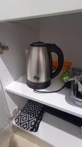 a black and silver tea kettle on a shelf at M&M's house in Thessaloniki