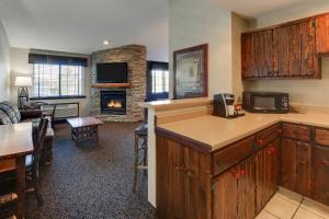 a kitchen with a living room with a fireplace at Stoney Creek Hotel Des Moines - Johnston in Johnston