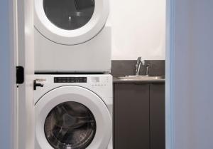 a washing machine in a kitchen with a sink at Altitude Adjustment by Revelstoke Vacations in Revelstoke