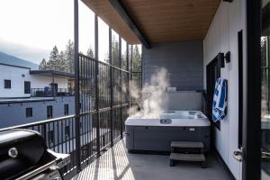 a barbecue on the balcony of a house at Altitude Adjustment by Revelstoke Vacations in Revelstoke