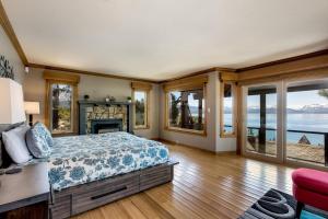 Schlafzimmer mit einem Bett, einem Kamin und Fenstern in der Unterkunft Tahoe Lakescape in Zephyr Cove