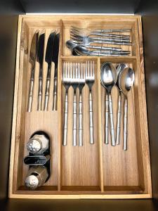 a wooden box filled with utensils and spoons at Emerald Apartment in Arad
