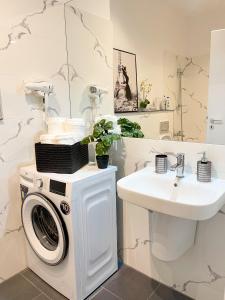 a bathroom with a washing machine and a sink at Emerald Apartment in Arad