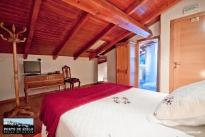 Schlafzimmer mit einem Bett und einem Schreibtisch mit einem TV in der Unterkunft Porto de Rinlo in Rinlo