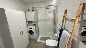 a bathroom with a shower and a washing machine at Cristal House 250 meters from Monte Gordo beach in Monte Gordo